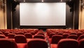 Empty cinema with red chairs and white blank screen Royalty Free Stock Photo