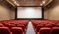 Empty cinema with red chairs and white blank screen Royalty Free Stock Photo