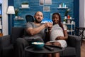 POV of interracial couple with pregnancy watching movie Royalty Free Stock Photo