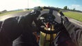 POV: Having fun racing a go kart along a bumpy asphalt racetrack on a sunny day