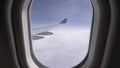 POV: Looking at the endless clouds and large metal wing of a modern airplane