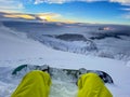 POV: Looking at sunset while sitting in fresh snow during a snowboarding trip