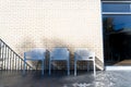 POV looking at urban outdoor cafe seating against a brick wall