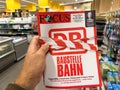 POV male hand buying latest newspaper magazine Focus with article about DB