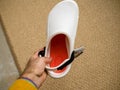 POV male hand holding against rug background Crocs at work comfortable shoes