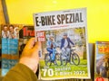 POV male hand holding new E-bike spezial german biking newspaper magazine with Royalty Free Stock Photo
