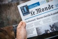 POV male hand holding reading French Le monde newspaper with lockdown