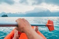 POV of Man floating in kayak holding paddle during early morning tour. Khao Sok national park, Cheow Lan lake, Thailand