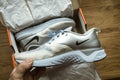 POV man hand Unboxing unpacking on wooden table pair of new Nike female running