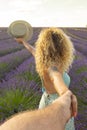 Pov of man holding woman hands with beautiful lavender field in background. Happy couple in travel lifestyle enjoying amazing