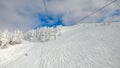 POV: Riding the ski lift over the tracked slopes of a ski resort in Slovenia. Royalty Free Stock Photo