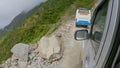 POV: Scary shot of driving along a bumpy road next to a steep grassy hill.