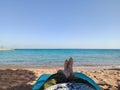 POV shot with focus on the legs. View from the eyes of man to the sea from the beach of Hurghada city, Egypt