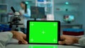 Pov shot of microbiologist holding tablet with green chroma key