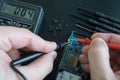 Pov shot of technician hands measure voltage, amperage on broken smartphone by multimeter with probes