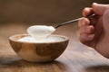 Pov shot of young female hand with full spoon of yogurt sitting at the table