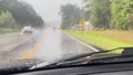 Windshield wipers wipe away heavy rain while car drives