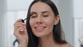 Pov smiling girl applying mascara at bathroom. Confident model preparing makeup Royalty Free Stock Photo