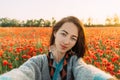 POV of smiling woman taking selfie in flower field.