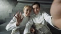 POV of Two young fencers man and woman have online video call with trainer using smartphone camera after fencing