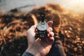 POV view of traveler hold compass in hand and legs in hiking boot. Blurred background Royalty Free Stock Photo