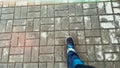 POV walking on tiled road. American tourist wearing blue jeans and boots. Going out. Copy space. Background with city Royalty Free Stock Photo