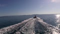 POV of waterskiing on surfboard behind a rubber boat