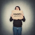 Poverty as global social and economic issue. Stressed man, refugee or beggar, holding a cardboard sheet with a text message.