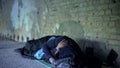 Poverty, homeless young man sleeping on street, indifferent egoistic society Royalty Free Stock Photo