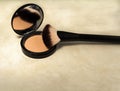 Powder and brush on a textured beige background. Cosmetic powder. Powder with a mirror. Facial cosmetics.