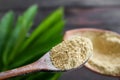 Powder Tanaka on wooden spoon with blur green leaves.