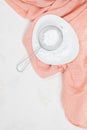 Powdered confectioners sugar in sieve. Closeup over pastel background