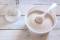 Powdered infant formula in a spoon while preparing child food mash next to a baby bottle Royalty Free Stock Photo