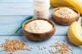 Powdered milk and oatmeal, banana baby food mix, on blue wooden, side view Royalty Free Stock Photo