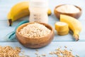 Powdered milk and oatmeal, banana baby food mix, on blue wooden, side view, selective focus Royalty Free Stock Photo