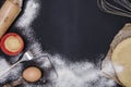 Powdering by flour rolled out dough for bakary stics with wooden rolling pin over black basground. Royalty Free Stock Photo