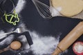 Powdering by flour rolled out dough for bakary stics with wooden rolling pin over black basground. Royalty Free Stock Photo