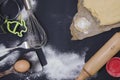 Powdering by flour rolled out dough for bakary stics with wooden rolling pin over black basground. Royalty Free Stock Photo