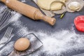 Powdering by flour rolled out dough for bakary stics with wooden rolling pin over black basground. Royalty Free Stock Photo