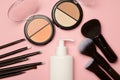 Powdery blush, container with an applicator and makeup brushes on a pink background. Cosmetic makeup set Royalty Free Stock Photo