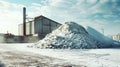 A powdery pile of snow covers the ground in front of a massive warehouse, where the production of potash fertilizers takes place