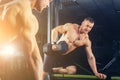 Power athletic guy , execute exercise press with dumbbells, in sport hall Royalty Free Stock Photo