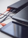 Power bank charges your laptop and phone using different cables. Simultaneous charging of different devices. Modern innovative Royalty Free Stock Photo