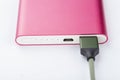 Power bank for charging mobile devices. Pink smart phone charger with power bank. battery bank Royalty Free Stock Photo