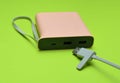 Power bank for charging smartphones and gadgets with a usb cable close-up on a green background. Modern technologies Royalty Free Stock Photo