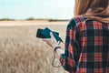 Power Bank in the hand of a girl, against the background of a yellow field.