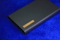 Power bank 11000 mAh, gray on a blue background of microfiber cloth Royalty Free Stock Photo