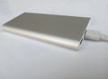 A power bank with a silver metal case and a connecting cable Royalty Free Stock Photo