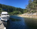 A power boat docked close to shore on a peaceful day on Cortes Island, Desolation Sound, British Columbia, Canada