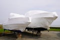 Power boat parked water protected by plastic film for wintering New boats in cover casing shrink wrap on sailboat stored for